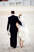Bridal pair walking on sand