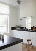 Moderne Küche in Weiß und Schwarz und einem Vintage-Hocker