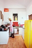 Kitchen with white furnishings & yellow fridge providing a splash of colour