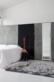 Minimalistisches Galerieschlafzimmer mit grauem Flokatiteppich und großem Standspiegel an grauer Trennwand