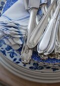 Monogrammed cutlery on blue-patterned plates