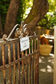 Rusty garden gate with sign warning of dog in French