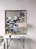Pinnwand mit silberfarbenem Bilderrahmen als Sammelort für Erinnerungsfotos
