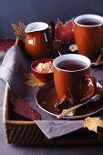 Tablett mit Teetassen, Zucker und Milch, dekoriert mit Herbstblättern