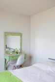 Lindgrüner Vintage Schminktisch mit Spiegel und Schalenstuhl in reduziert möbliertem Schlafzimmer