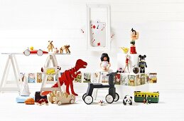 Spielzeug-Stillleben mit Dino und Dreirad