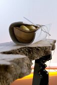 Stilisierte Jägermahlzeit - Holzschale mit Kartoffeln in Filzplatte gewickelt auf improvisiertem Rohholztisch
