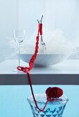 Oriental place setting: forks in bowl of glass noodles bound with red woollen yarn
