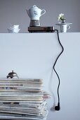 Espresso pot on hotplate on wall behind retro desk bell on stack of magazines