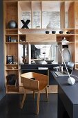 Stylish home office area with wooden, designer shell chair and elegant, fitted partition shelving