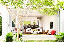View from summery garden into open-plan modern living area