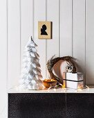Stylised Christmas tree made from polystyrene cone covered in white ribbon strips, fairy lights and willow wreath on sideboard