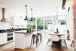 Moderner offener Wohnraum mit Sichtmauerwerk - Essbereich mit Küche vor Terrassentür