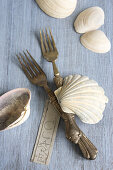 Silver forks, seashells and name tag