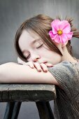 Dreaming girl with pink cosmos flower in hair