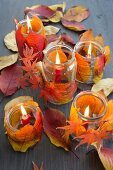 Candle lanterns decorated with autumn leaves