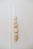 Wooden balls of different sizes threaded on cord as handle of cupboard door