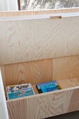 Wooden bench with open lid used as storage for books