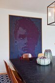 View across dining table to large, modern portrait on wall