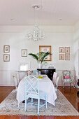 Chairs of various styles and Rococo chandelier in dining area in rustic interior