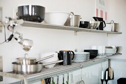 Black and white crockery on metal wall rack in corner of kitchen