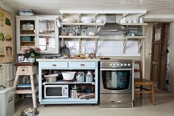 Rustic kitchen in mixture of styles; fifties-style base cabinet next to stainless steel cooker in rustic house