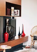 Extravagante, schwarze und rote Vasen in 70er Jahre Einbauregal mit Fernseher