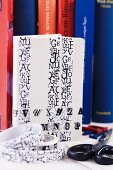 White notebook decorated with washi tape with pattern of letters