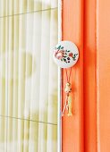 Retro furniture knob with floral motif and small tassel on cupboard door