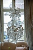 An antique chandelier with a price label in front of a window