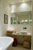Narrow bathroom with mirror, dramatic lighting, floating washstand and counter-top basin