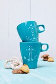 Blue mugs with anchor motifs in cross-stitch look