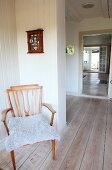 Retro armchair with fur blanket in corridor of Swedish wooden house