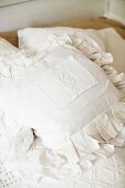Initials embroidered on cushion with white cover and ruffles