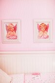Zwei Engelsbilder an rosa Wand über weißem Kinderbett aus Holz