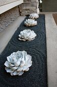 Rosettes of succulents in bed of gravel raked into circular pattern