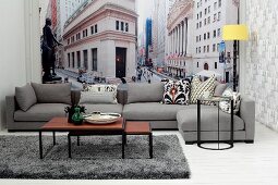 Set of coffee tables and grey sofa in front of New York mural wallpaper