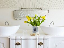 Vintage Kommode als Waschtisch mit zwei Aufbaubecken; gelber Tulpenstrauss in Vase