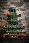 Stylised Christmas tree made from stacked, green antiquarian books with red candles