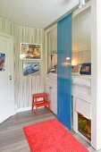 Sliding panel curtain made of blue voile screening cubby bed with storage space and aquarium below in teenager's bedroom