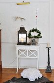 Lantern and ivy arch on Scandinavian side table below magnetic whiteboard with motto
