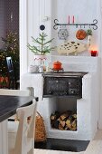 Masonry stove element with antique, cast iron firebox and rustic ornaments; dining area in foreground