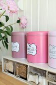 Retro storage tins in shades of pink on spice rack