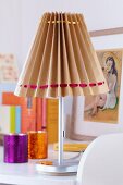 Table lamp with lampshade hand-crafted from brown paper and satin ribbons