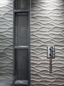 Metall Regal vor gefliester Wand mit dreidimensionaler Oberfläche