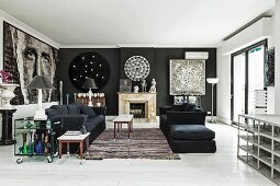 Black sofa set and delicate coffee table on rug in lounge area with black accent walls and large portrait n one wall