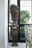 Planter on rusty, metal lattice plinth in loggia-style room