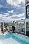 Pool with mosaic tiles in various shades of blue on penthouse roof terrace with view of Florence