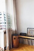 Vintage wooden speakers, record collection below sideboard in corner and glass display case of toy cars on windowsill behind curtain