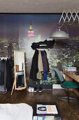 Teenager's bedroom with desk, clothes racks and cityscape mural wallpaper